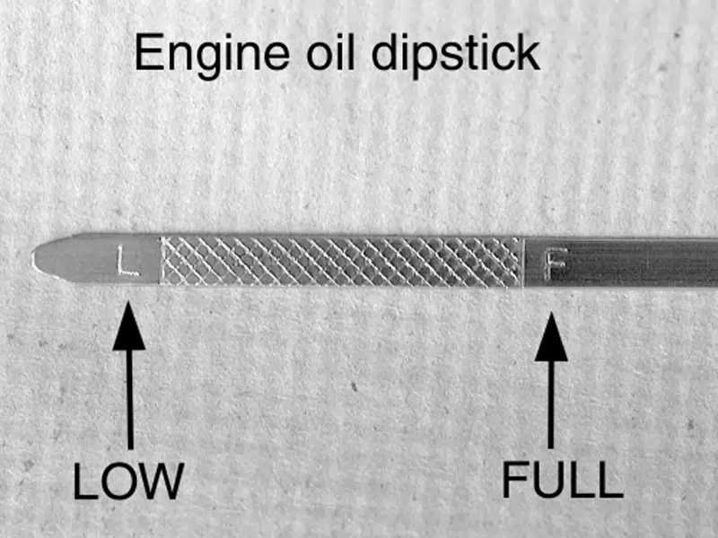 Checking engine oil level using the dipstick before driving