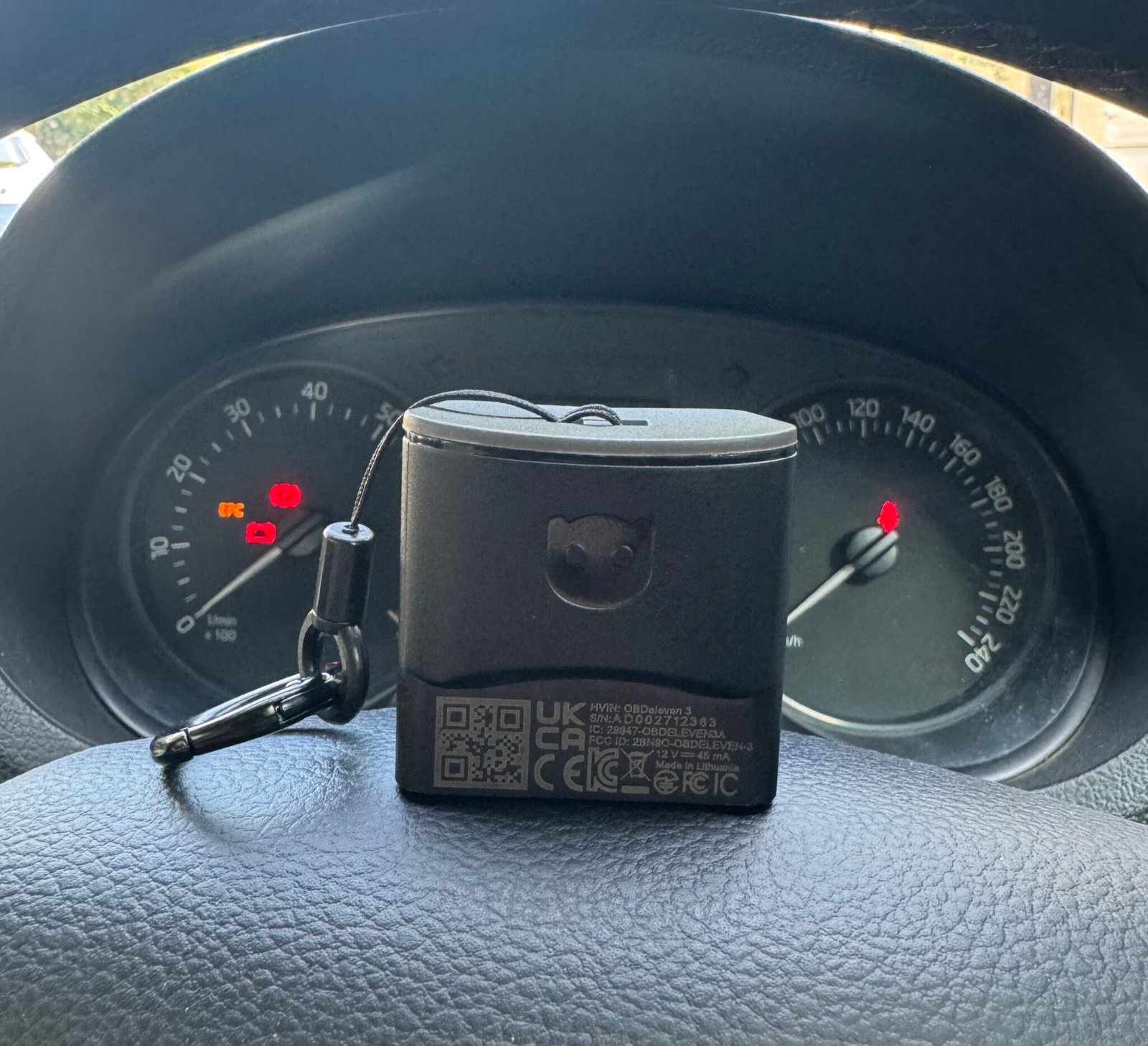 OBDeleven 3 device on the steering wheel of a 2021 Skoda Rapid, label side showing